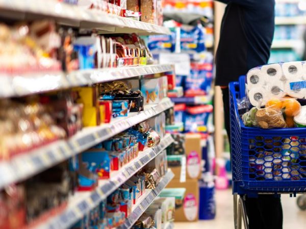 EInkaufsladen-Gang mit vollgepacktem Einkaufswagen